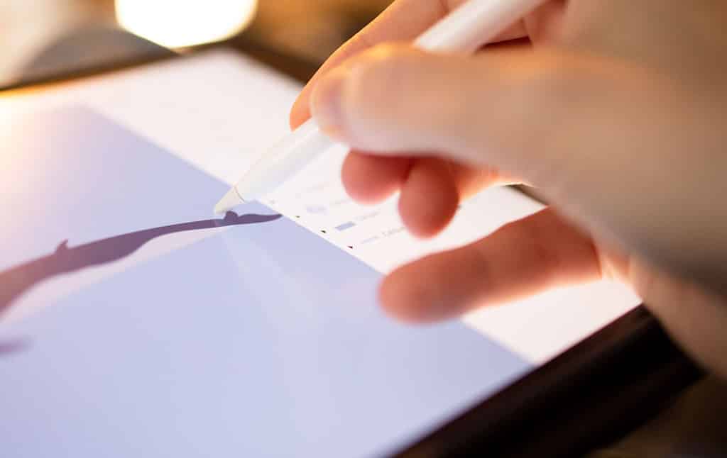 graphiste et nomade digital dessinant sur son iPad